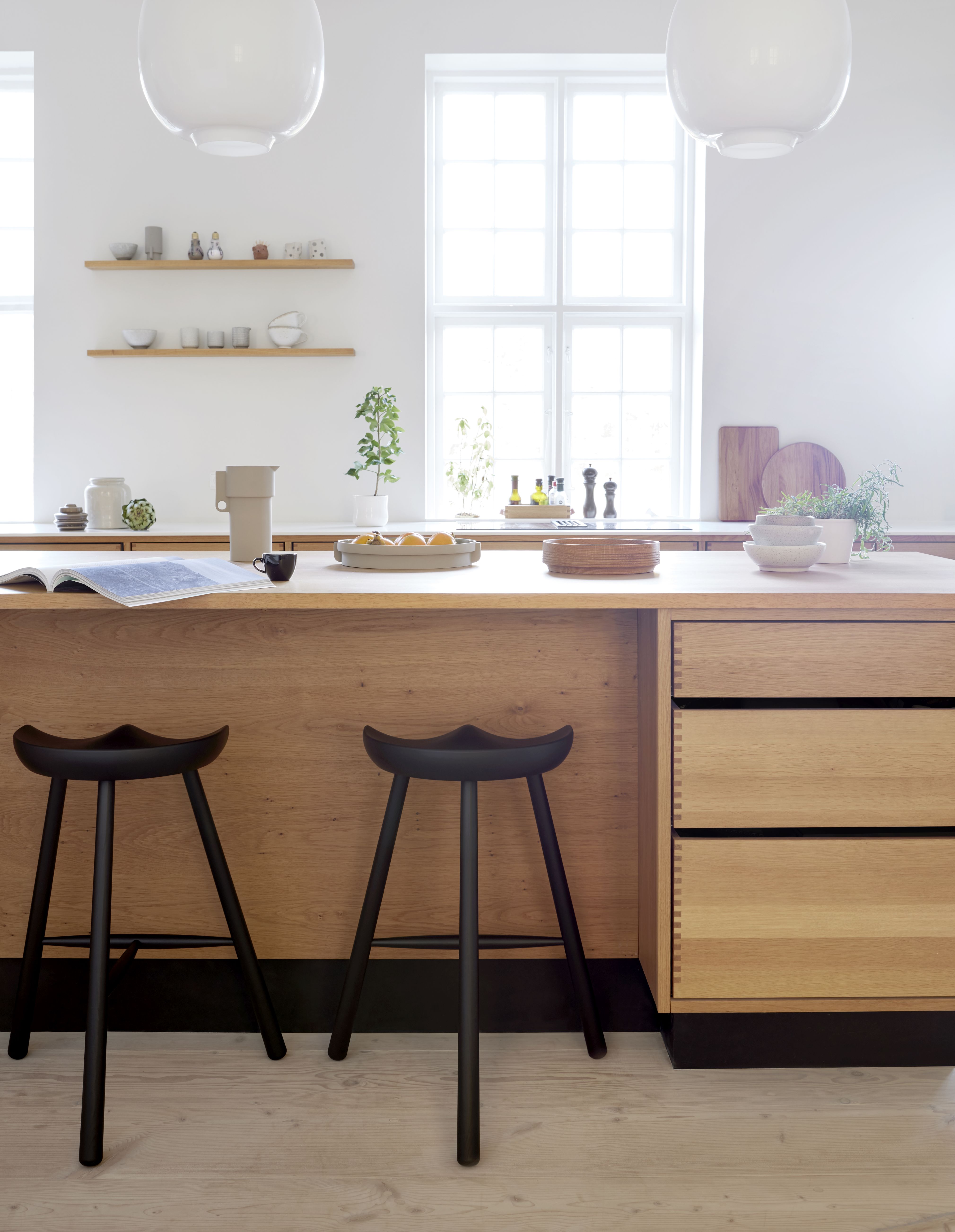 Zwei Shoemaker Chair No. 68 Barhocker aus geräucherter Eiche vor einer Kücheninsel.