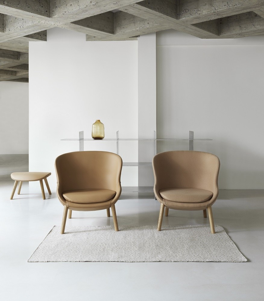 Beige Hyg Lounge Chair Low Sessel von Normann Copenhagen mit Hocker auf Teppich.