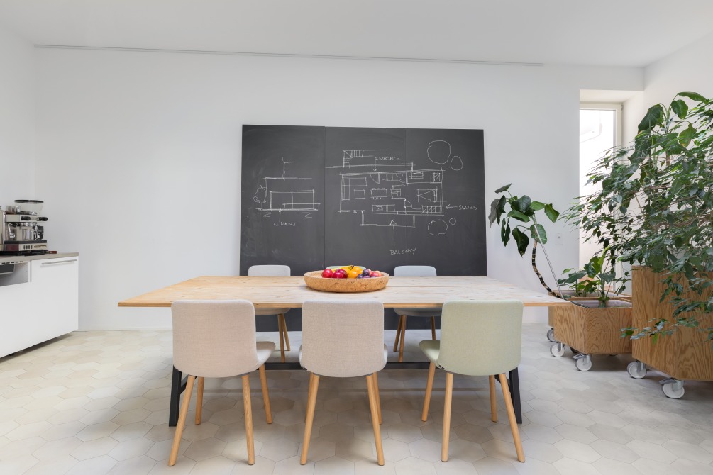 Esszimmer mit Holztisch und mehreren Hal Soft Wood Stühlen von Vitra.