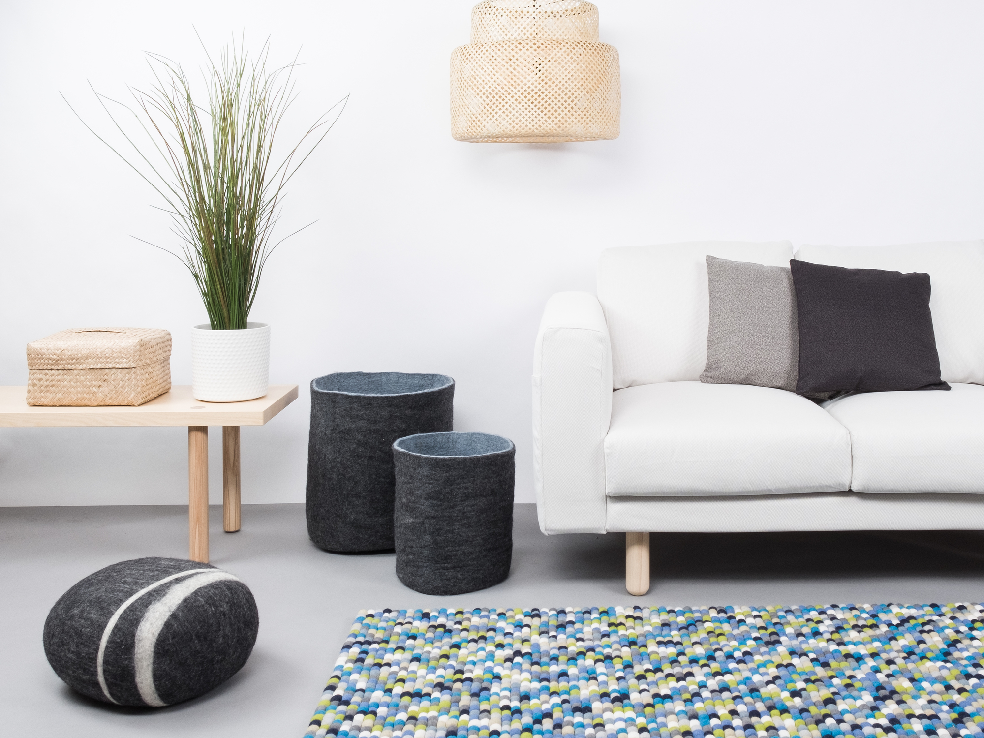 Myfelt Filzkugel Teppich 120x170 cm in einem Wohnzimmer mit Sofa und Dekoration.