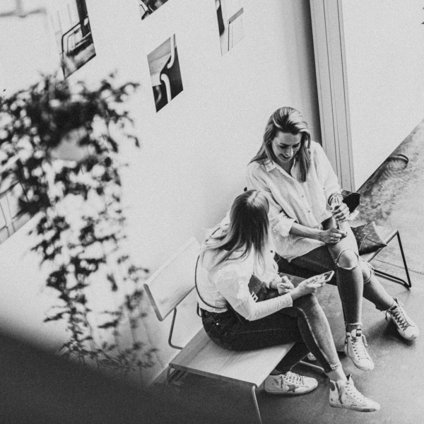 Zwei Frauen sitzen auf einem Loungechair von Fuchs & Habicht. Kohleschwarzes Designmöbel.