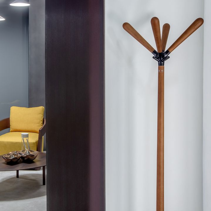 Sioux Kleiderständer aus Holz mit braunen Ärmen und schwarzer Halterung vor weißer Wand.