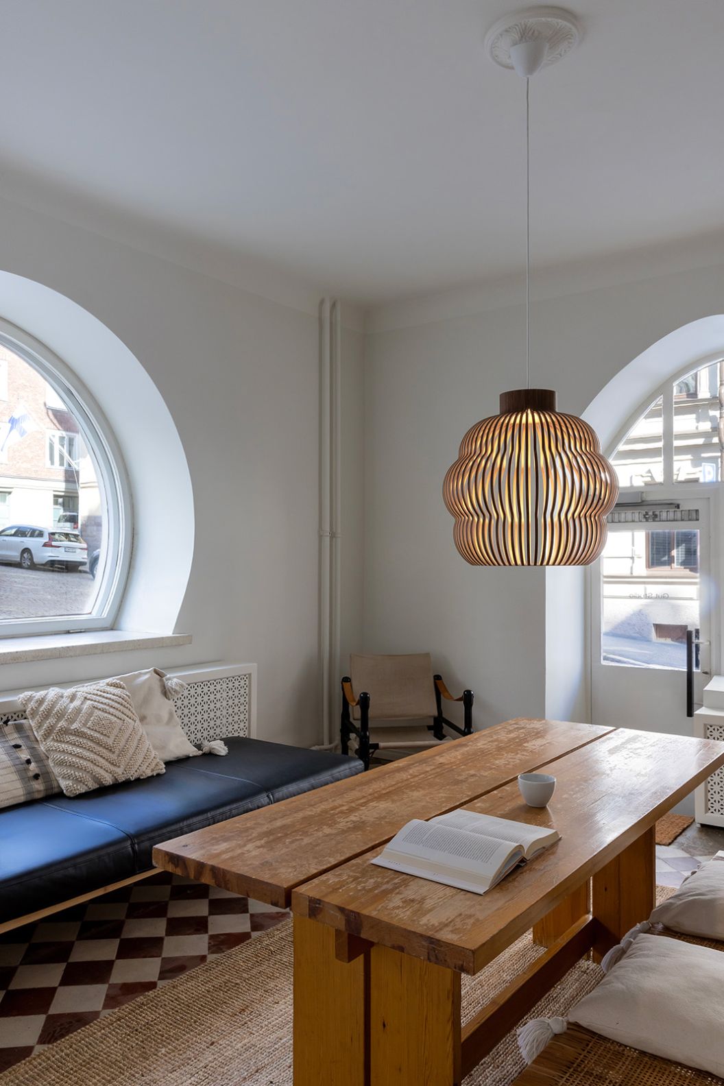 Kumulo Pendelleuchte von Secto Design aus Birke über einem Esstisch in einem hellen Raum.