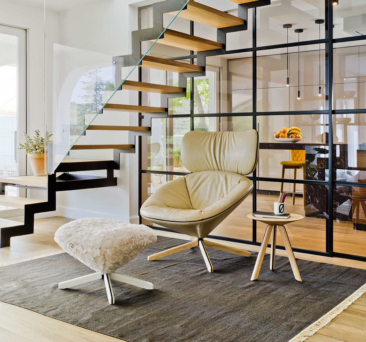 Beiger Tortuga Sessel von Sancal mit passendem Hocker und kleinem Beistelltisch auf einem grauen Teppich.