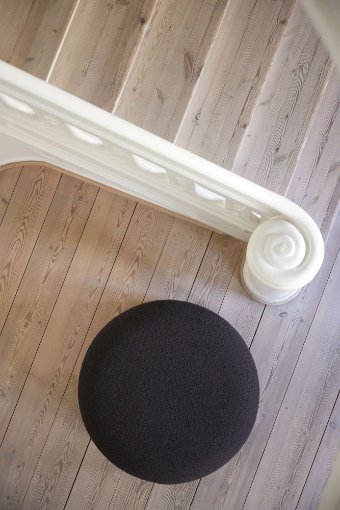 Dunkelgrauer Easy Pouf Hocker von Verpan auf hellem Holzboden neben weißem Treppengeländer.