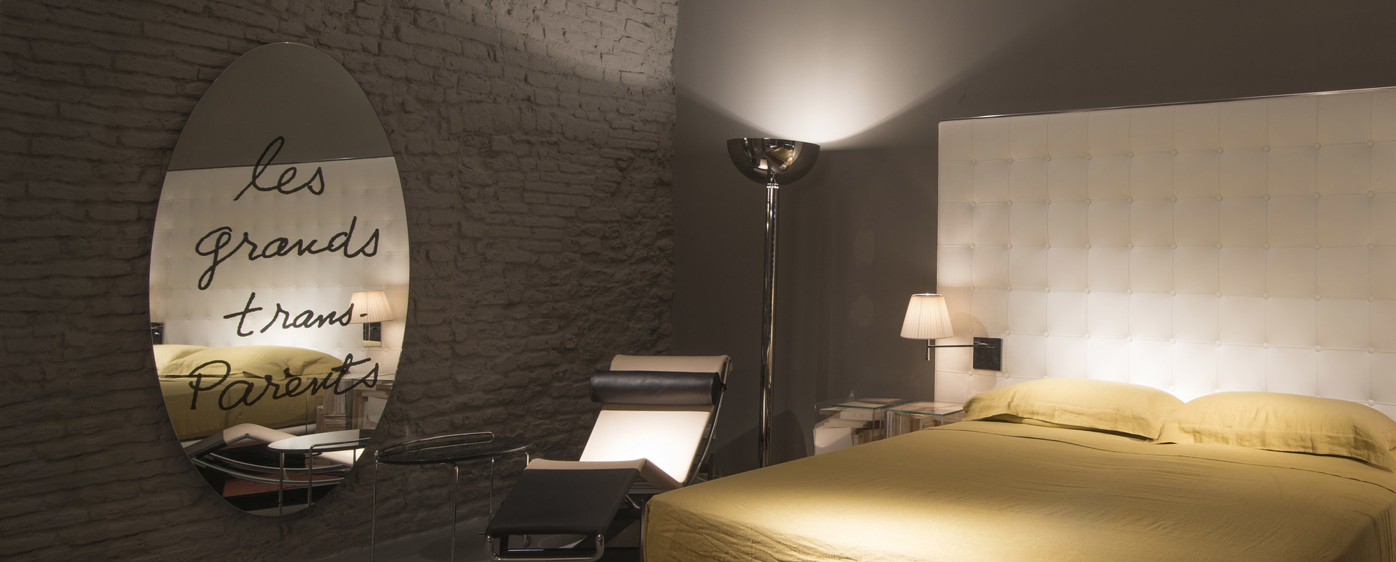 Ovaler "Les Grand Trans-Parents" Spiegel von Cassina im Schlafzimmer mit Bett und Sessel.