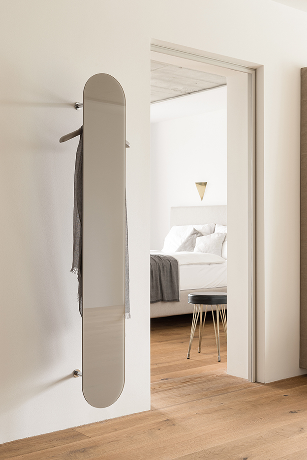 Slot Hängegarderobe von Schönbuch: Moderne Wandgarderobe mit Spiegel und Kleiderbügel im minimalistischen Schlafzimmer.