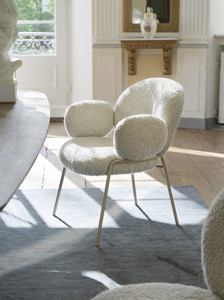 Nana Armchair von Freifrau Manufaktur: Weißer Sessel mit Armlehnen und Bouclé-Bezug im hellen Raum.