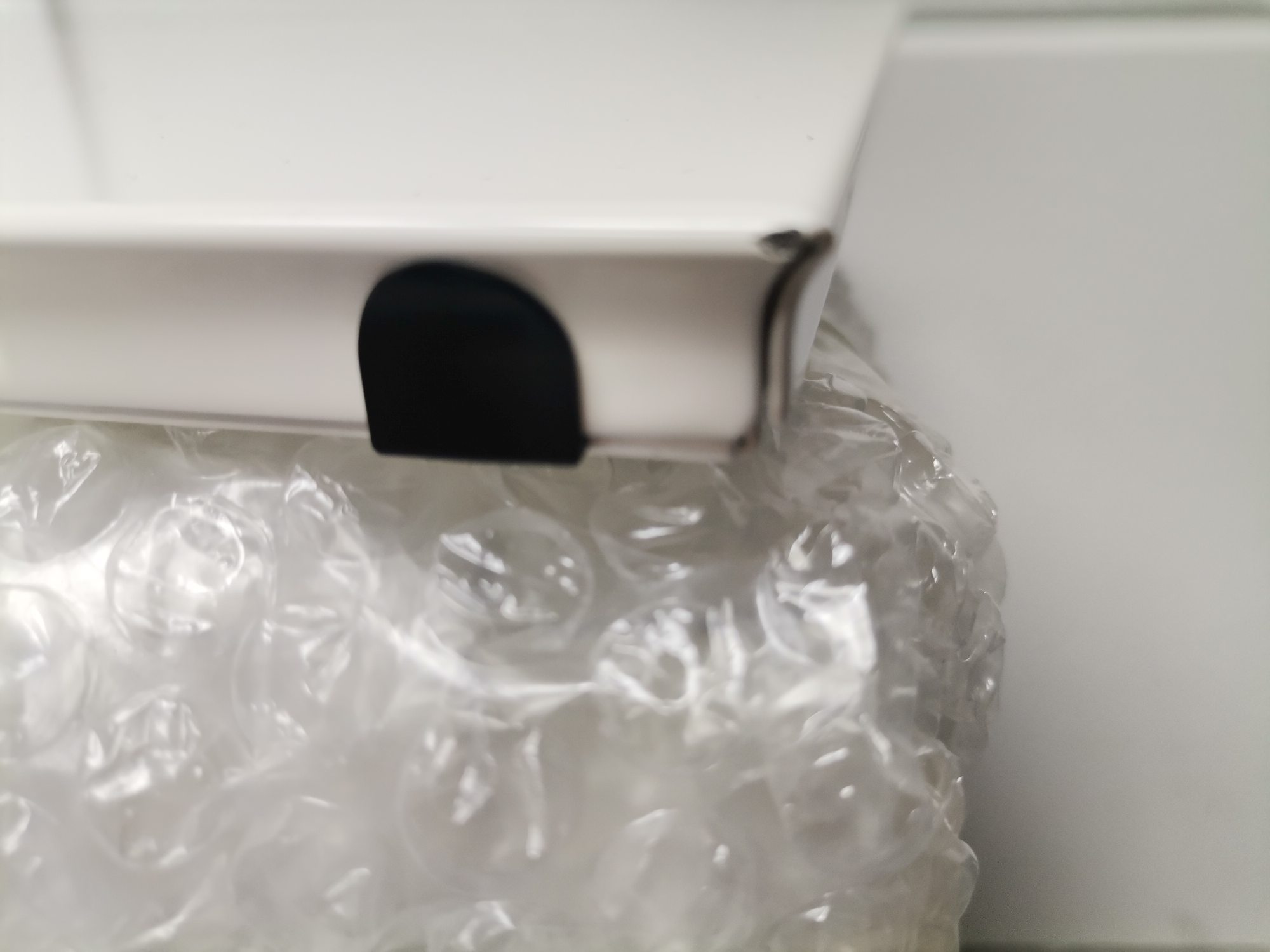 Nahaufnahme eines verpackten USM Haller Ersatzteils (Mängelexemplar) in Luftpolsterfolie, bereit für den Versand.