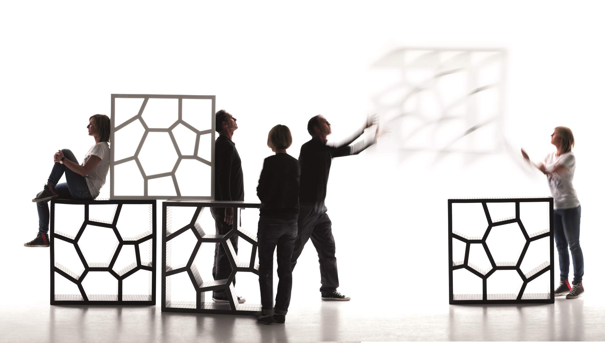 Opus Incertum Regal von Casamania Horm: Modulares Designregal mit geometrischem Muster und Personen.