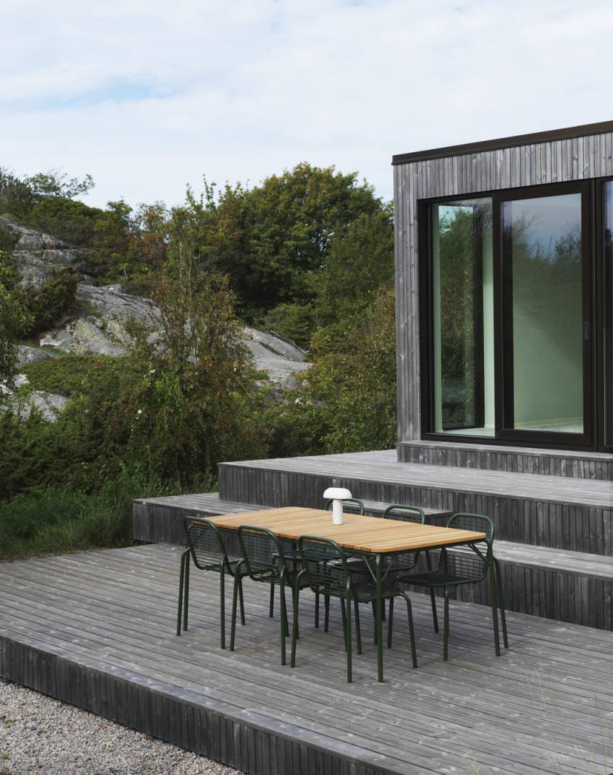 Normann Copenhagen Vig Chair Outdoor: Gartengarnitur mit Esstisch und grünen Stühlen auf Holzterrasse.