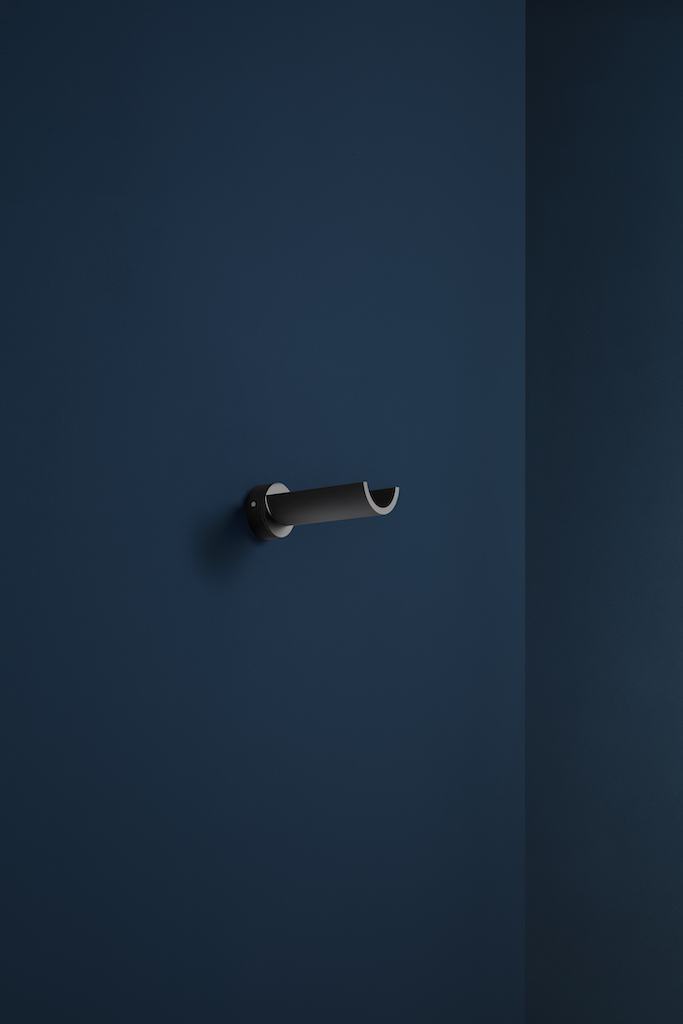 Nahaufnahme der modernen U. W Wandleuchte von Catellani & Smith in Schwarz an einer blauen Wand.