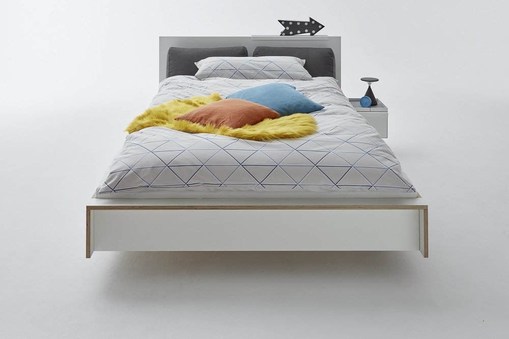 Weißes Flai Einzelbett von Müller Möbelwerkstätten mit Bettwäsche und Nachttisch.