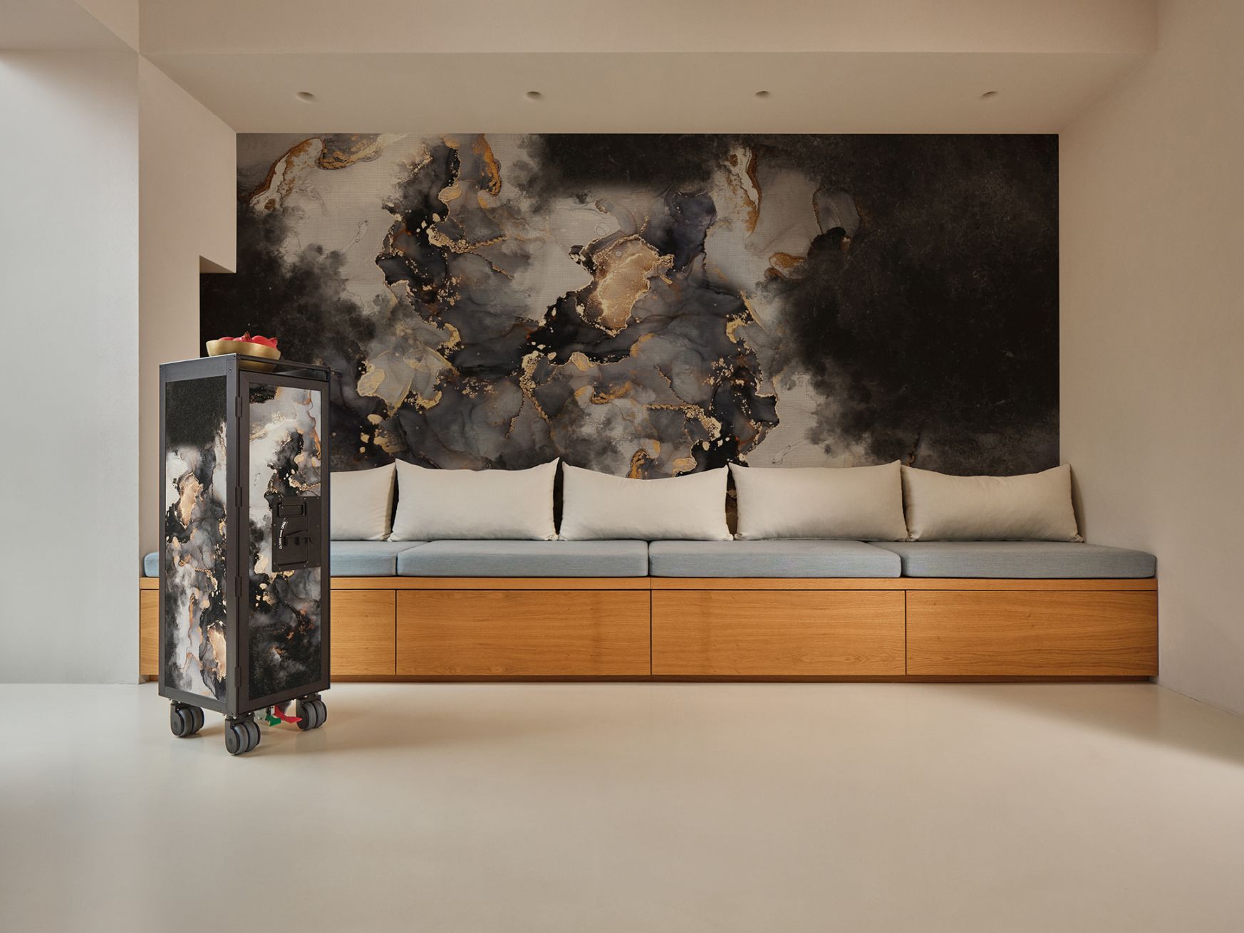 Bordbar Flugzeugtrolley Ayame mit Rauchglas-Design vor einer Wand mit abstraktem Muster.