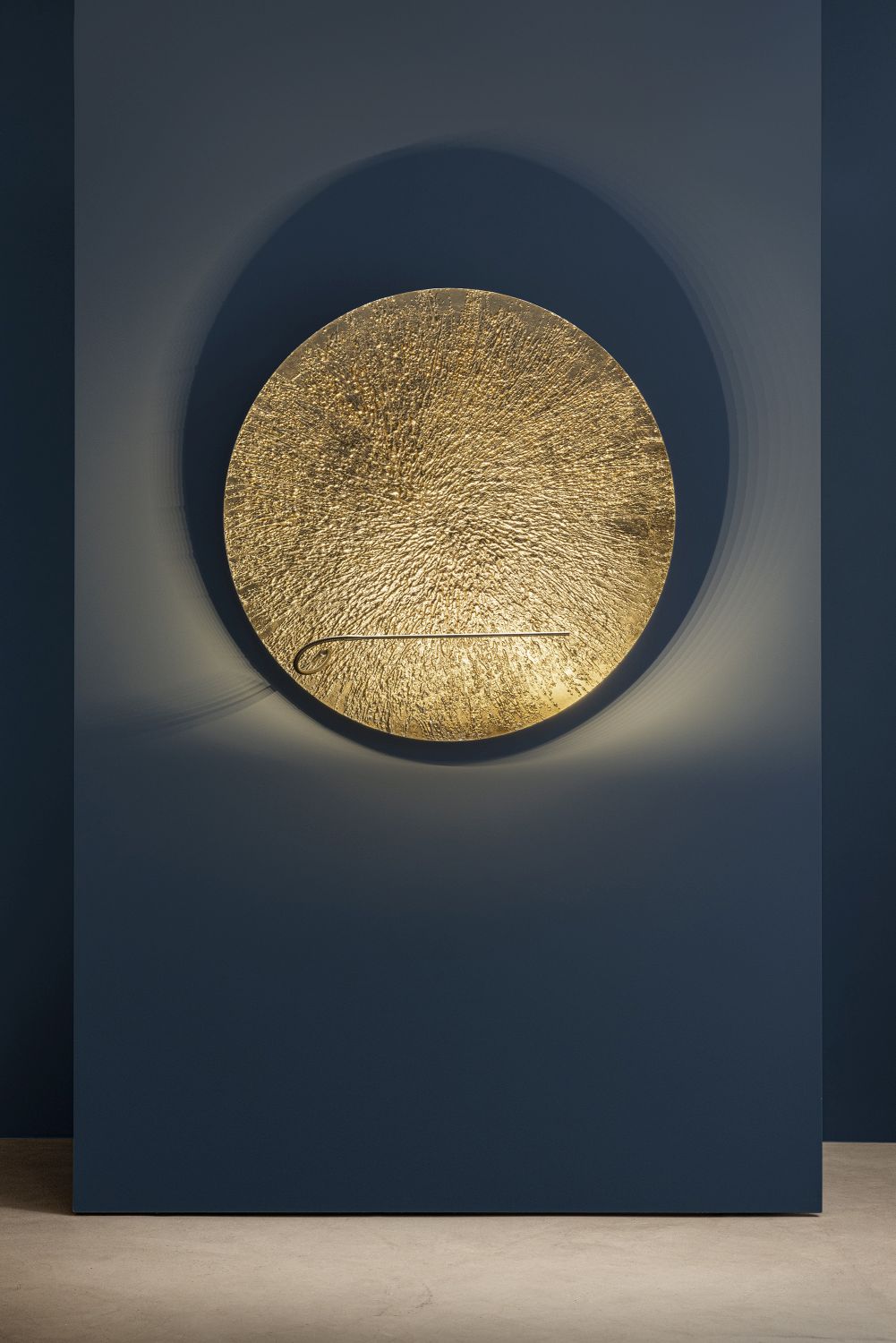 Goldene Bellatrix Wandleuchte von Catellani & Smith an blauer Wand, modernes Design, indirekte Beleuchtung.