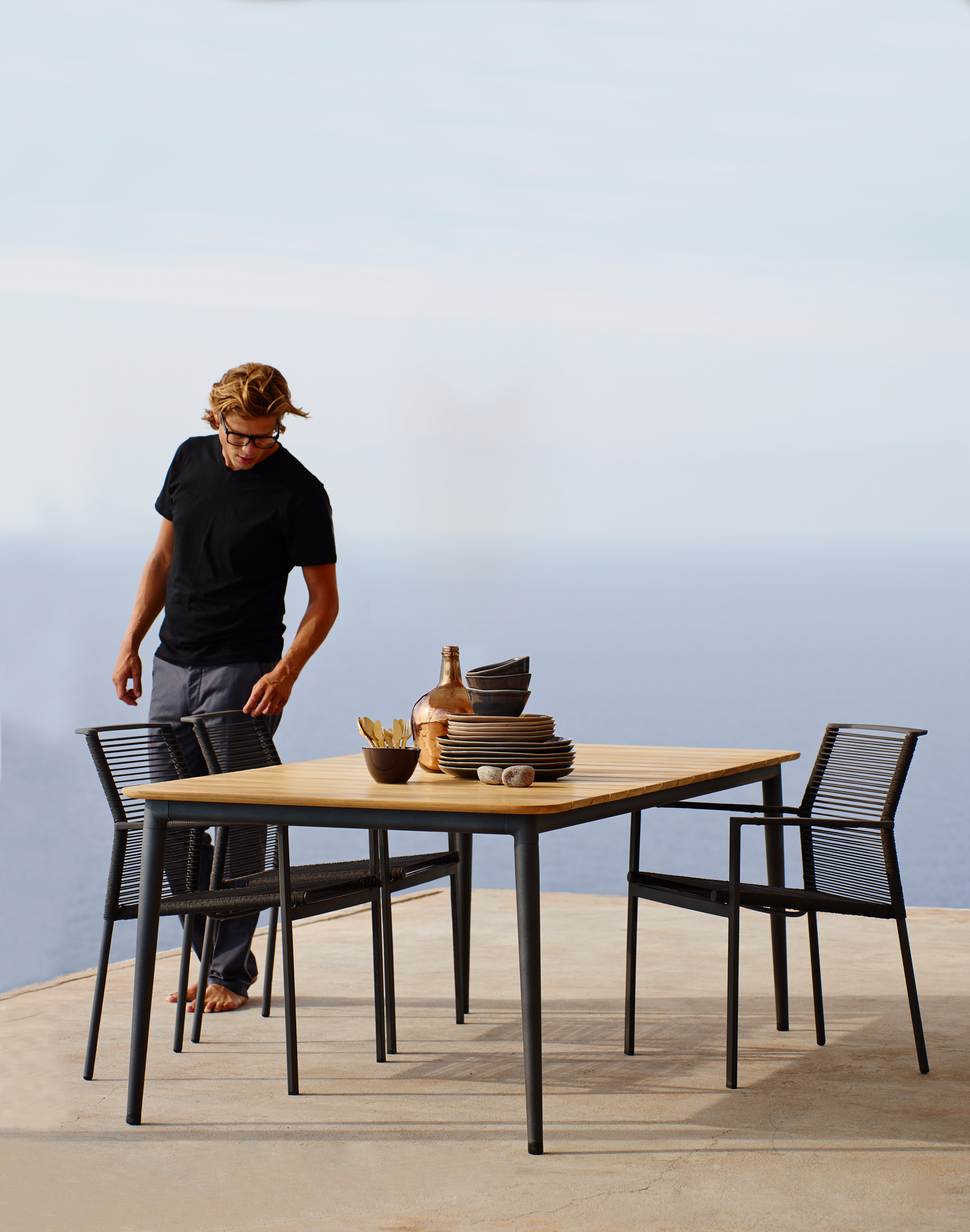 Cane-Line Edge Outdoor Sessel und Esstisch auf Terrasse mit Meerblick. Stapelbare Gartensessel.