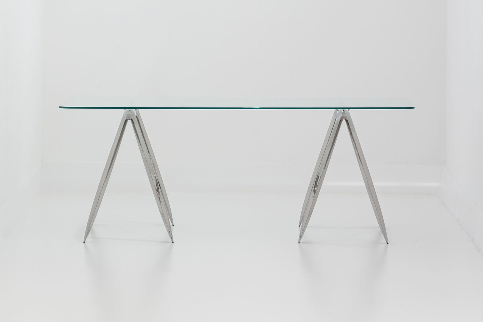 Koza Tischgestell von Zieta mit Glasplatte und silberfarbenen, dreieckigen Metallbeinen auf weißem Hintergrund.