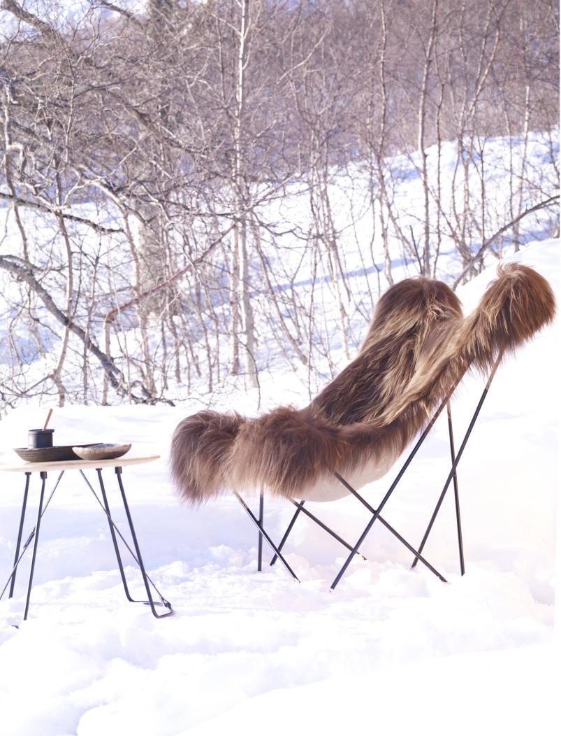 Iceland Mariposa Sessel mit Schaffellbezug in Grau vor verschneiter Winterlandschaft. Bequemer Design-Sessel.