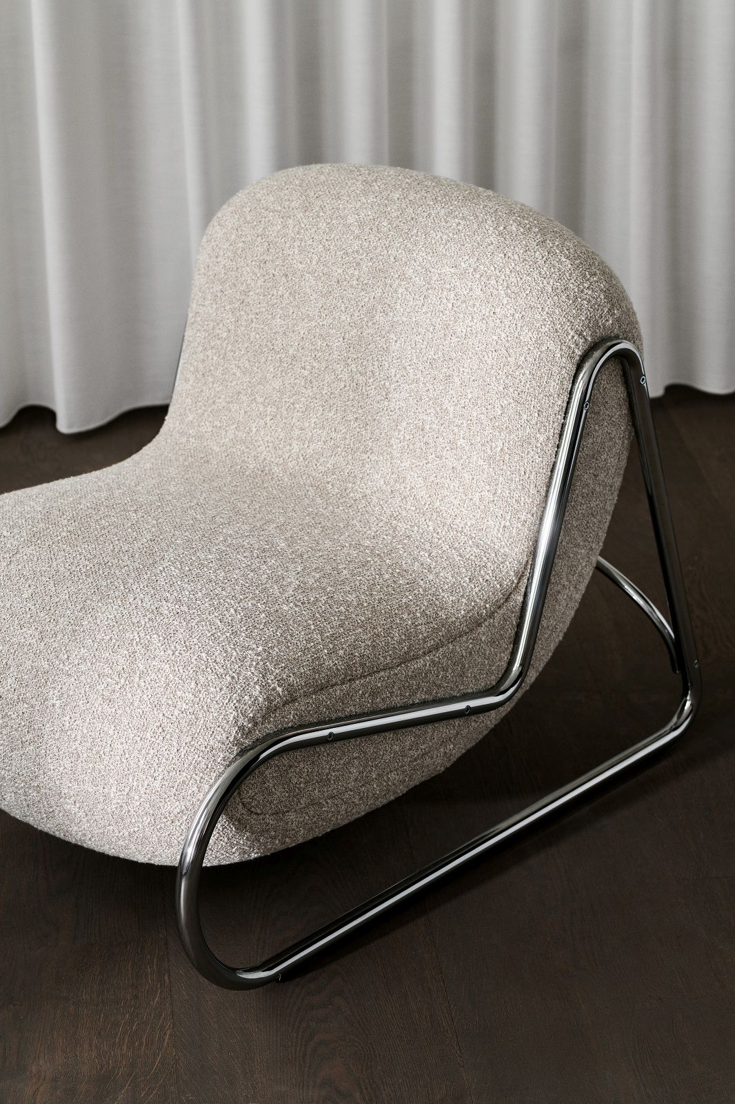 Beiger Boho Armchair Sessel mit Chromgestell von NORR11 auf dunklem Holzboden. Design Sessel.