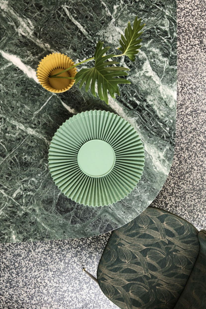 Draufsicht: Grüner Matégot Blumentopf von Gubi auf Marmortisch mit gelbem Übertopf und Pflanze.