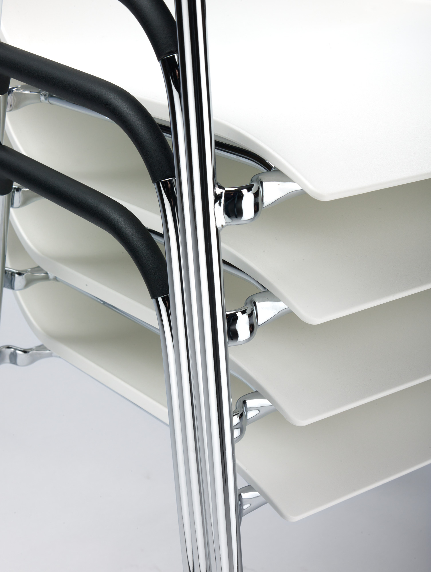 Gestapelte Thonet Stühle S 260 F mit Armlehne, weißer Sitzschale und verchromtem Gestell.