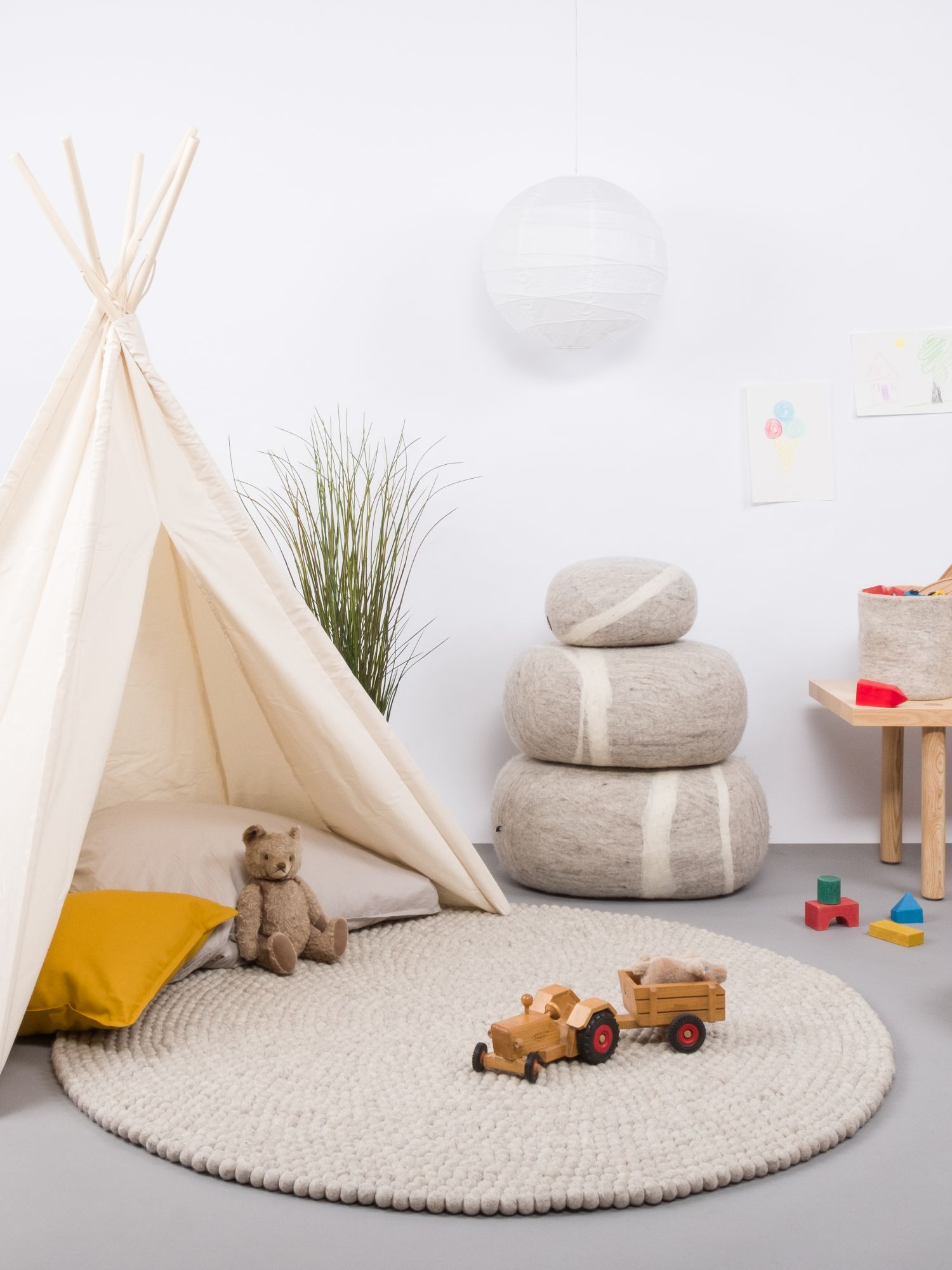 Kinderzimmer mit Filz Kieselstein Hocker von myfelt, Spielzelt, Spielzeug und rundem Teppich.