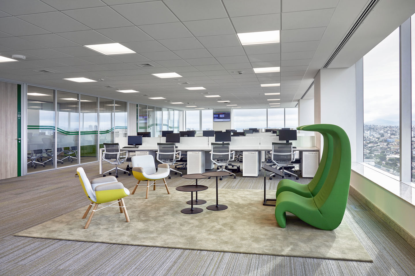 Grüner Amoebe Highback Sessel von Vitra in modernem Büro mit Fenster und Stadtblick.