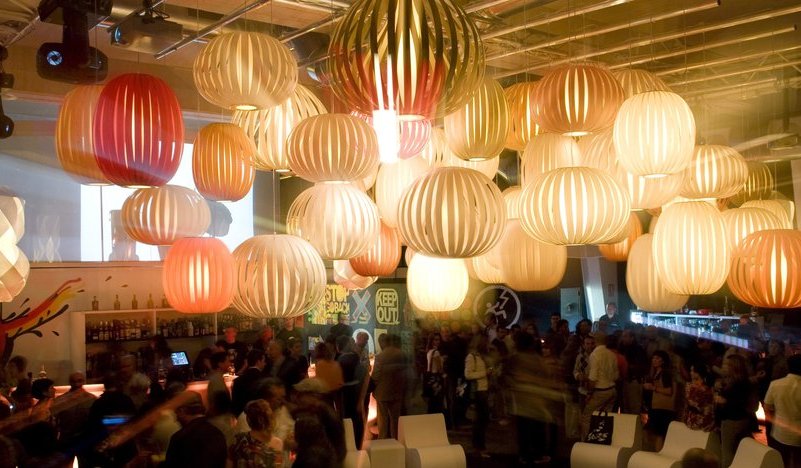 Viele LZF Lamps Pod Pendelleuchten in verschiedenen Farben hängen in einem Raum.