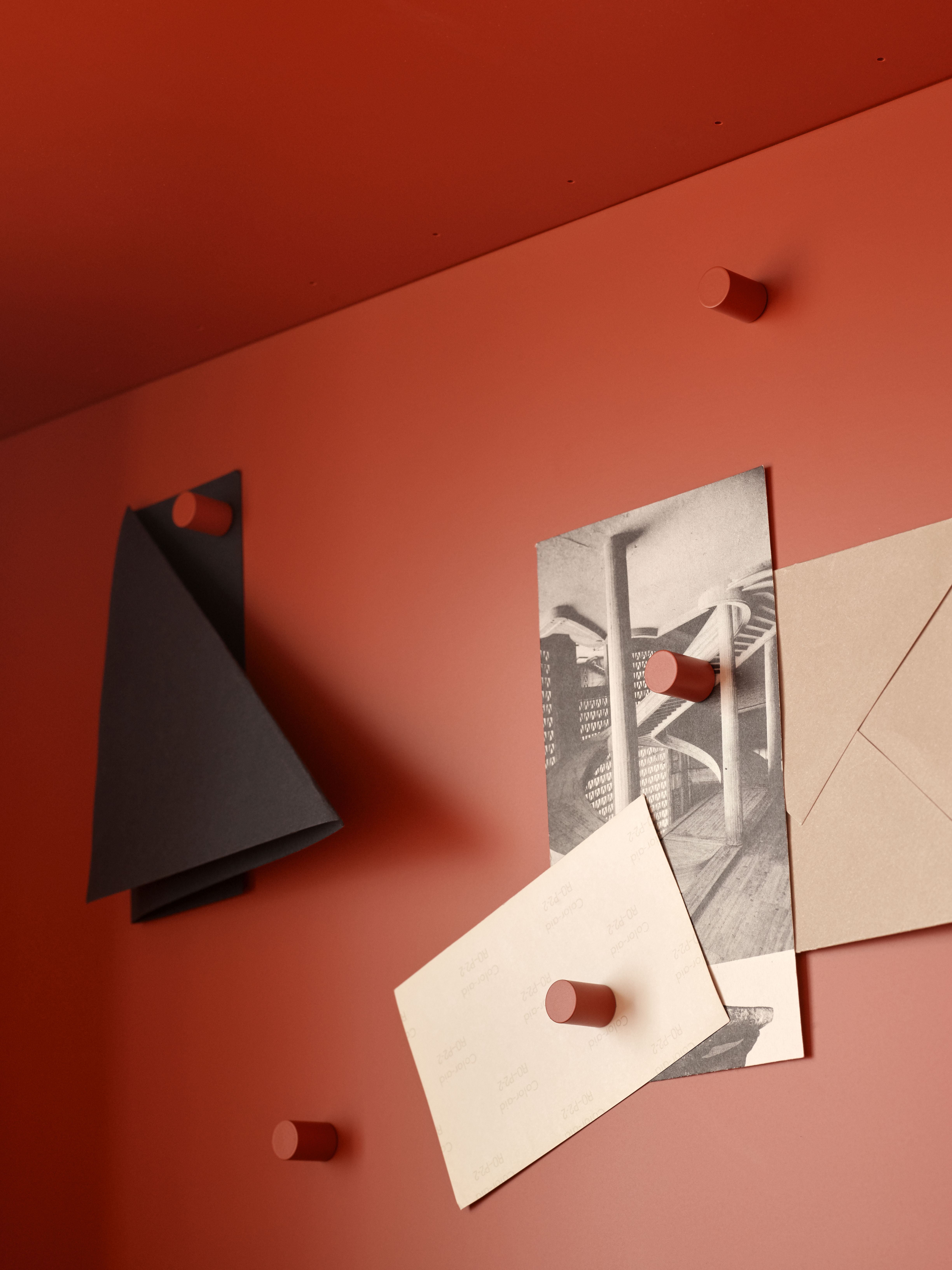 Detailaufnahme des STUDIO Sekretärs in Terrakotta mit Notizen und Umschlag an Magneten.