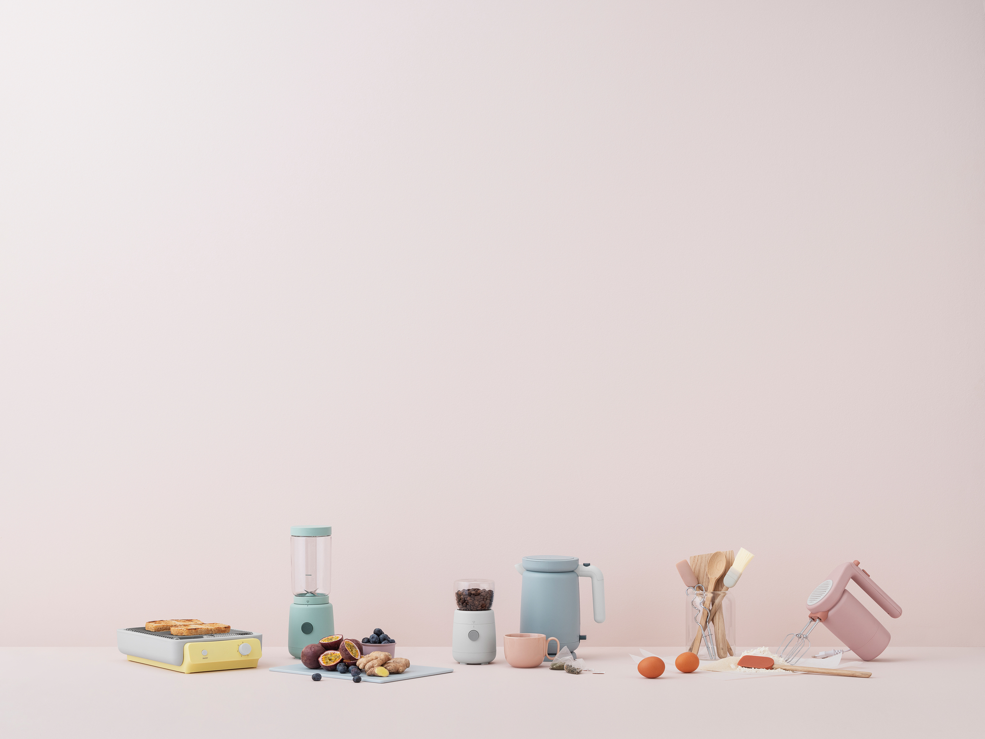 Hellrosa Foodie Handmixer von RIG-TIG by Stelton neben anderen Küchengeräten und Zutaten.