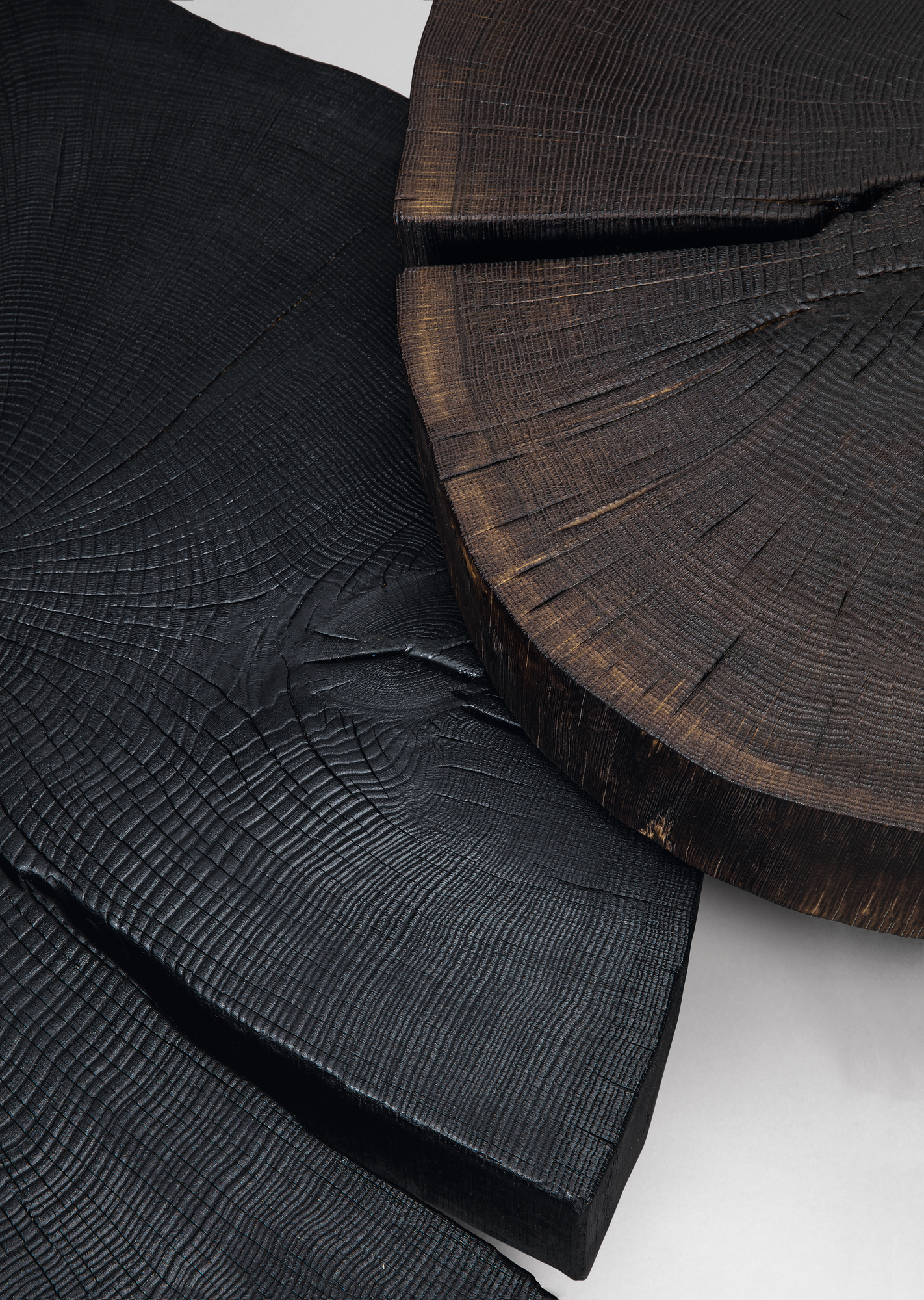 Detailansicht des geköhlten Stomp Beistelltischs von Janua, zeigt die einzigartige Holzstruktur und Oberfläche.