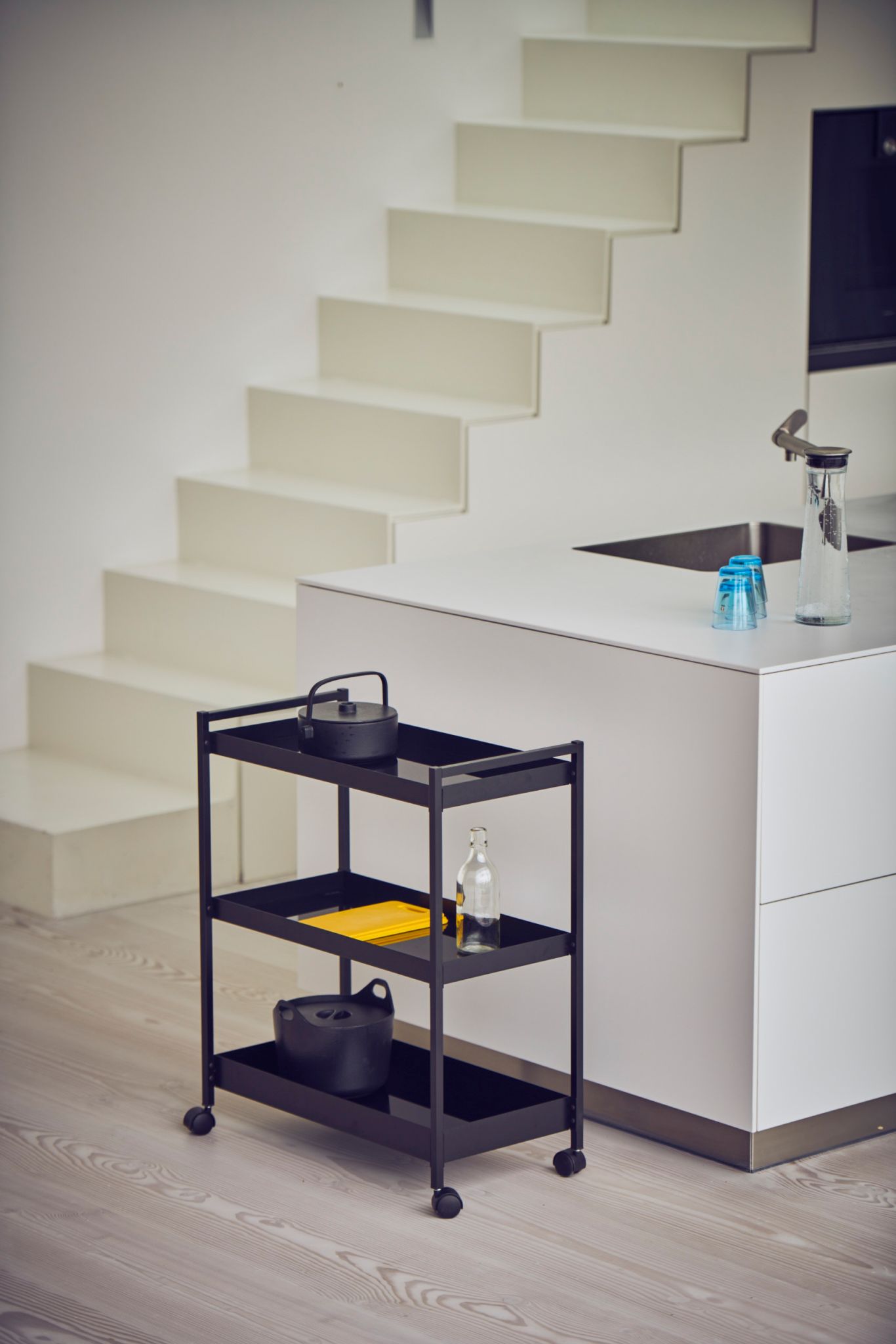 Schwarzer Jan Kurtz Servierwagen "Butler L" mit drei Ablagen und Rollen in moderner Küche.