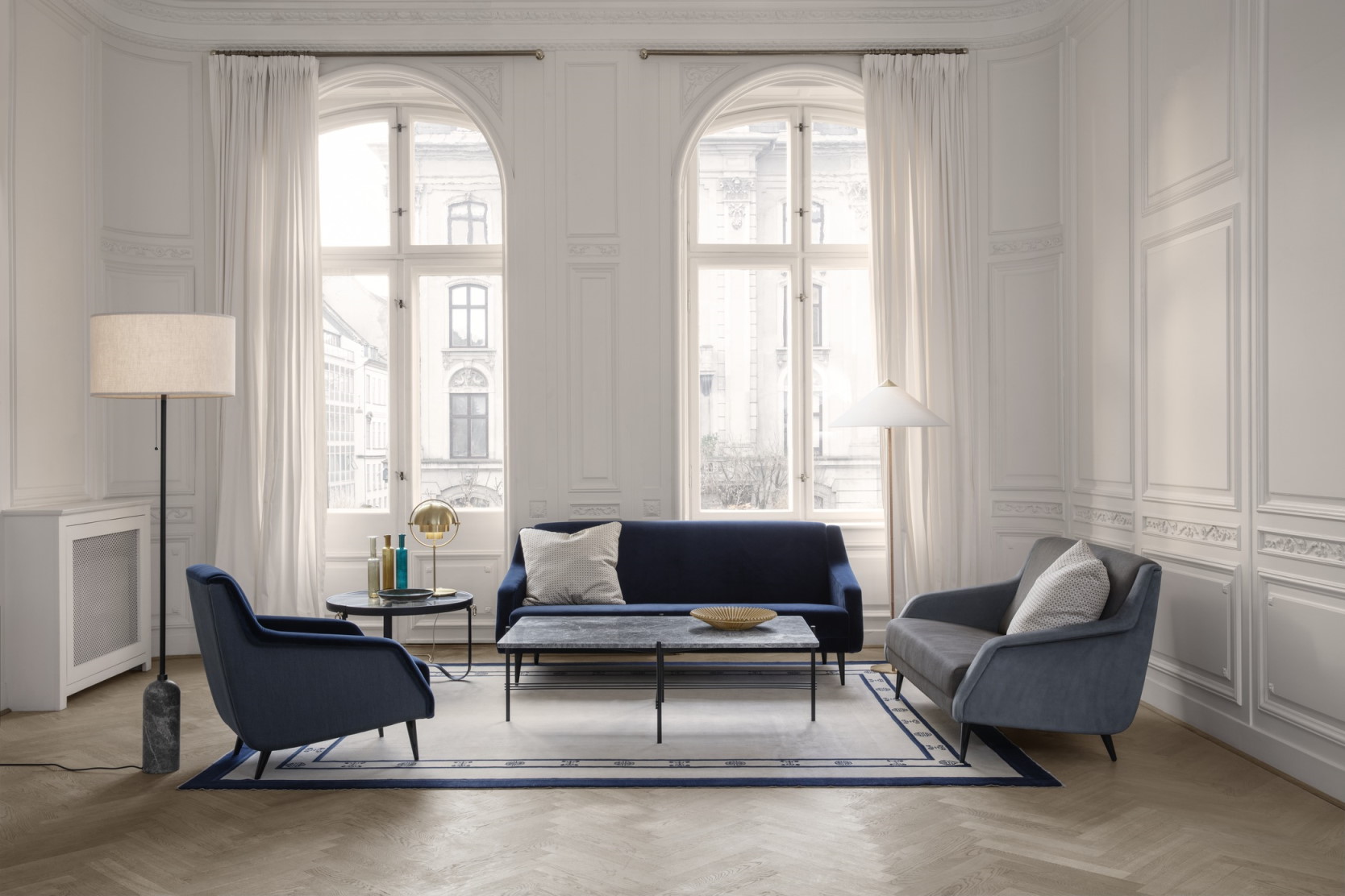 Helle Wohnzimmer-Szene mit Gubi Gravity Stehleuchte mit weißem Schirm und geschwärztem Stahlfuß.