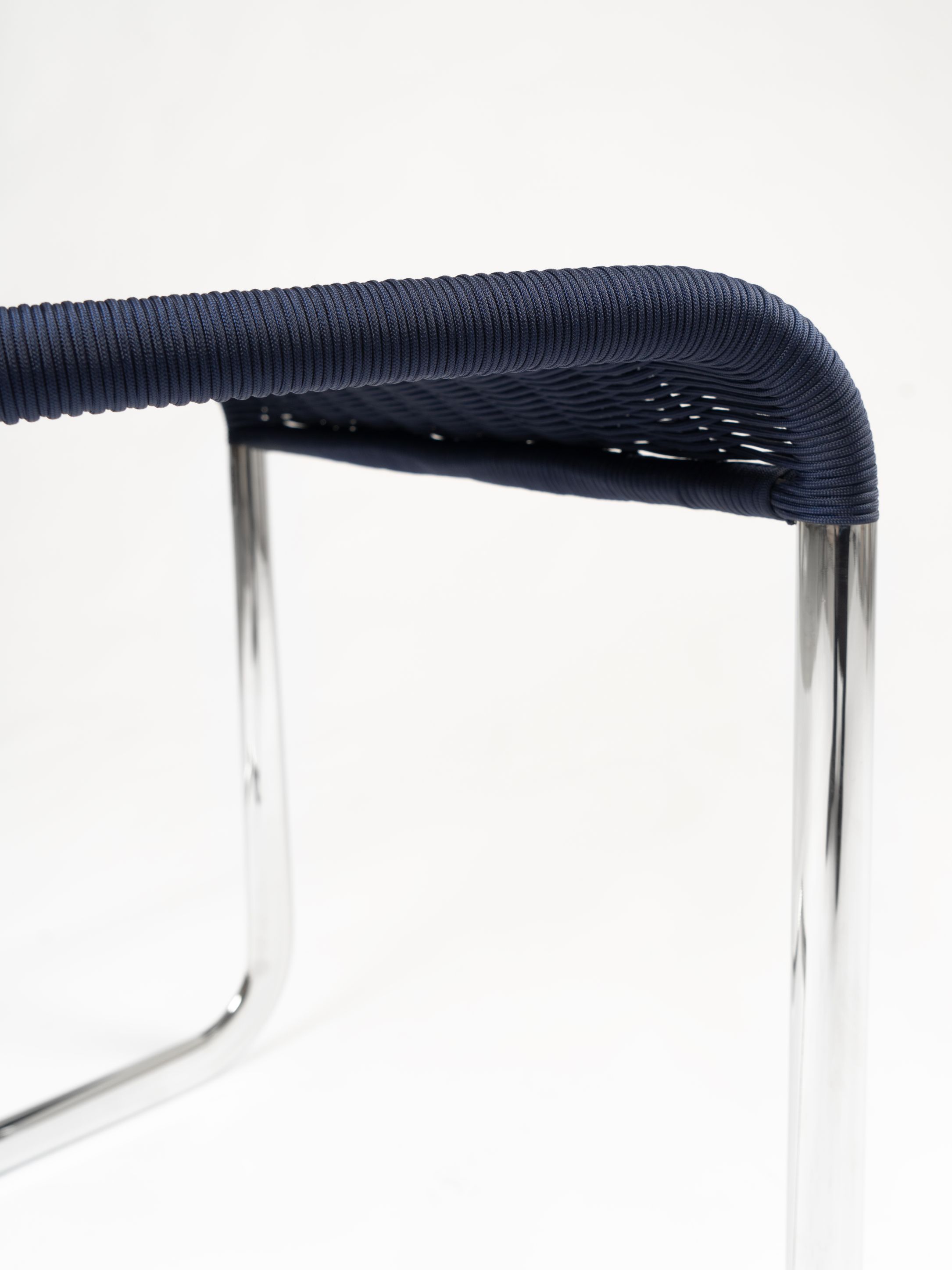 Detailaufnahme des B25 Kragstuhls von Tecta in Dunkelblau mit verchromtem Stahlrohr Gestell. Designklassiker.