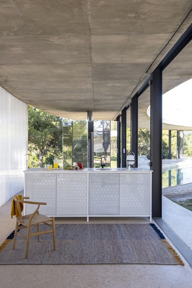 Grauer Re-Rug Teppich von Nanimarquina (ca. 200x300 cm) in modernem Wohnraum mit Stuhl.