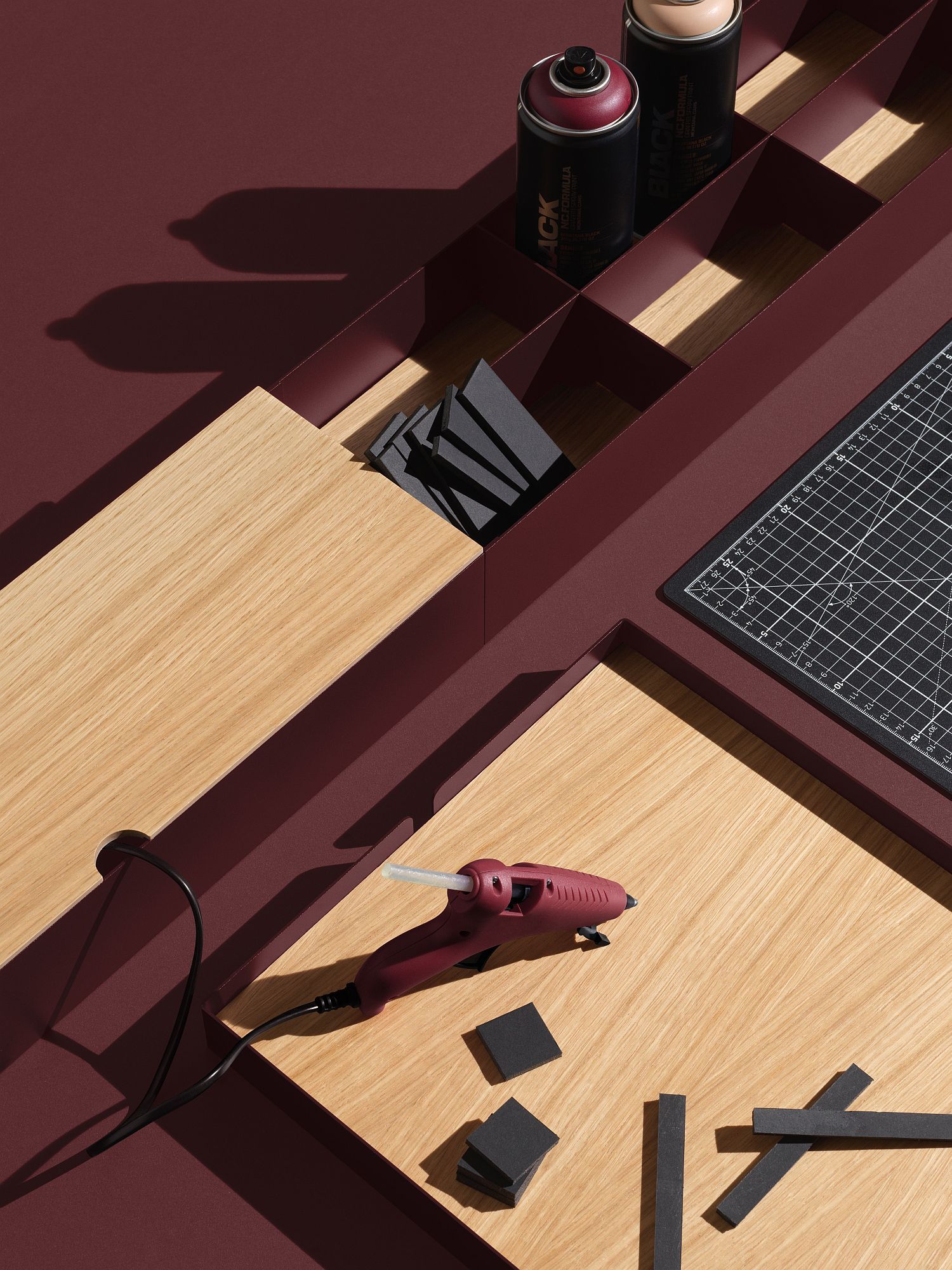 Detailaufnahme des Enfold Table/Work Table: Tisch mit Werkzeugen, Sprühdosen und Schneidematte für kreatives Arbeiten.