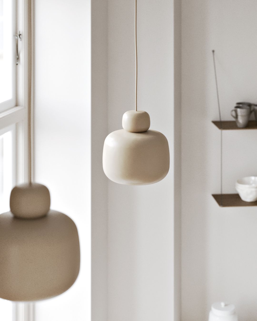 Nahaufnahme einer beigen Stone Pendelleuchte von Woud, moderne Hängelampe im minimalistischen Design.