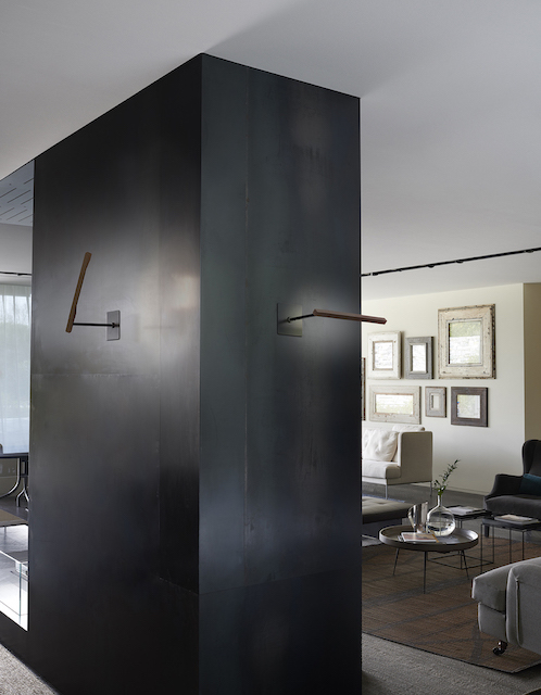 Ilo Wandleuchte von Oluce in Satin Bronze an einer Wand, moderne Innenarchitektur.