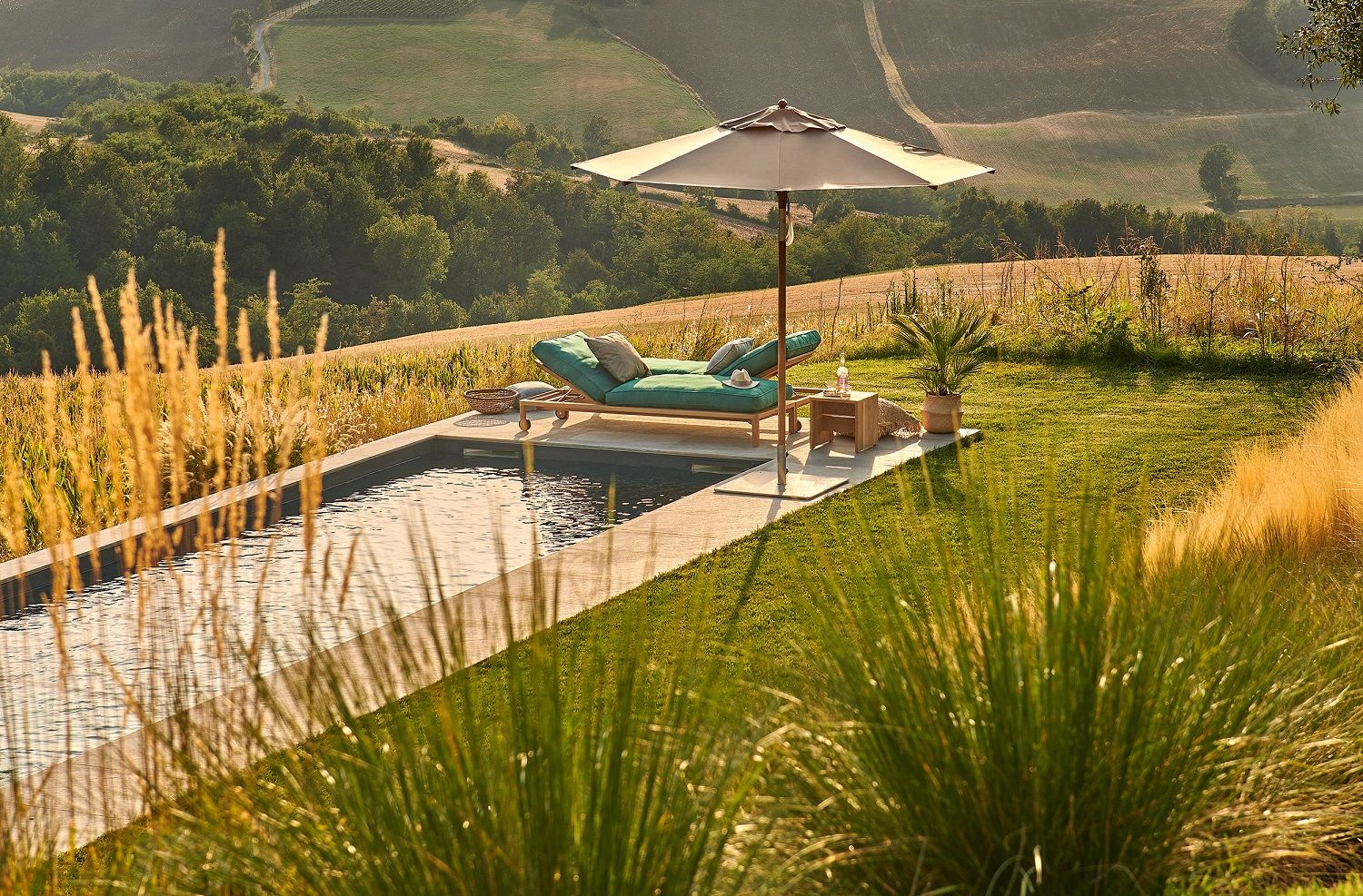 Weishäupl Teakschirm neben Pool und Liege, Sonnenschutz für entspannte Stunden im Garten.