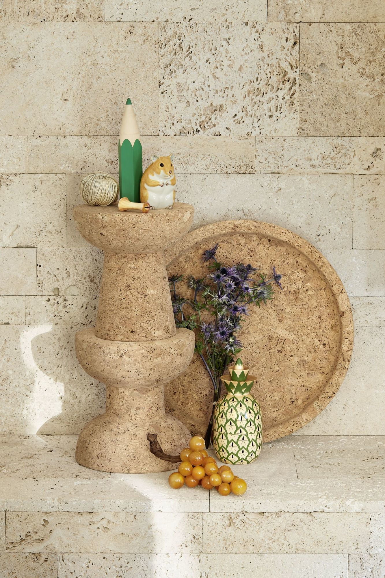 Vitra Cork Family Modell E Tisch/Hocker aus Kork mit Deko-Elementen auf beigem Untergrund.