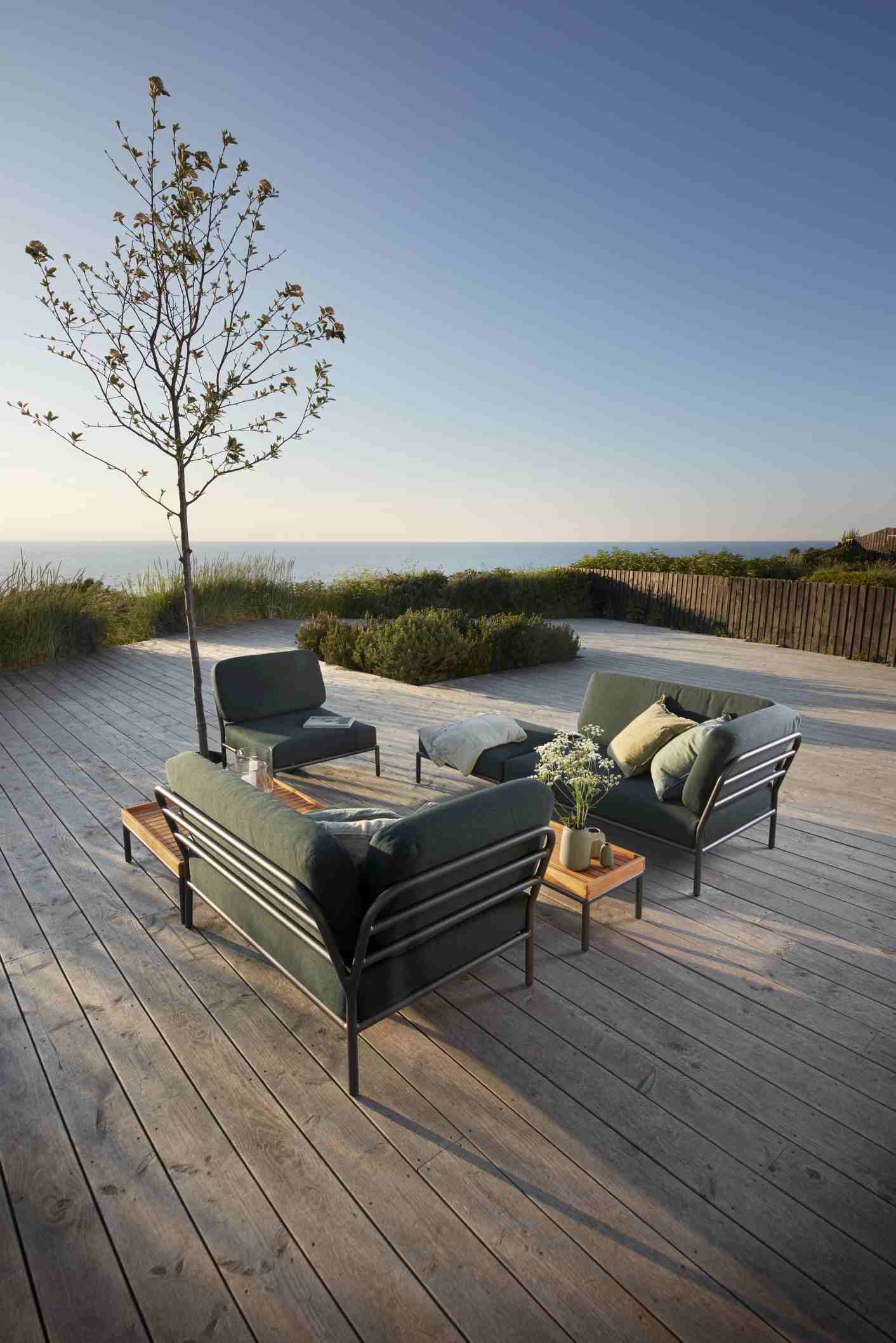 Houe Level Outdoor Lounge Möbel mit Beistelltisch auf Holzterrasse mit Meerblick.