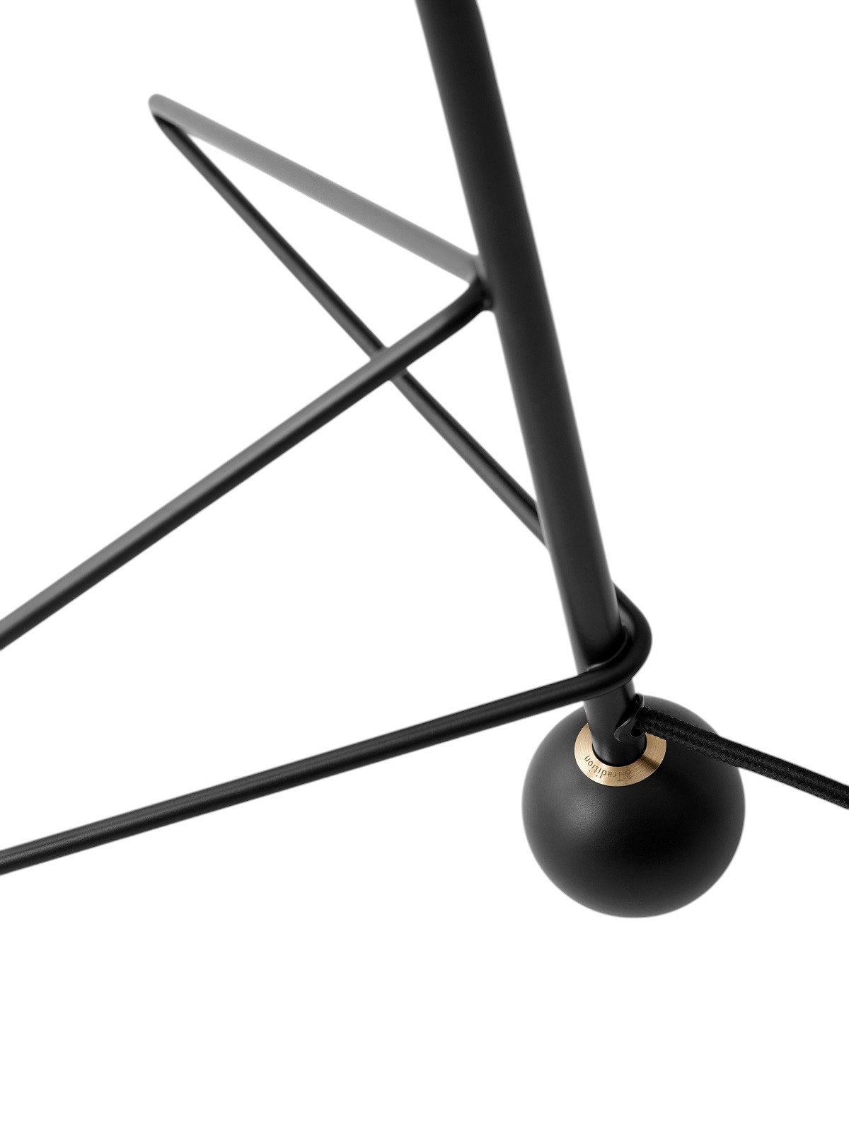Detailaufnahme des schwarzen Metallfußes der AndTradition Tripod HM9 Tischleuchte mit Kabel.
