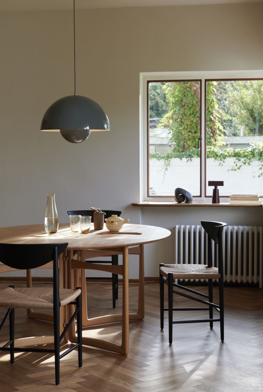 Graue Flowerpot VP2 Pendelleuchte von AndTradition über einem Esstisch in einem hellen Raum.