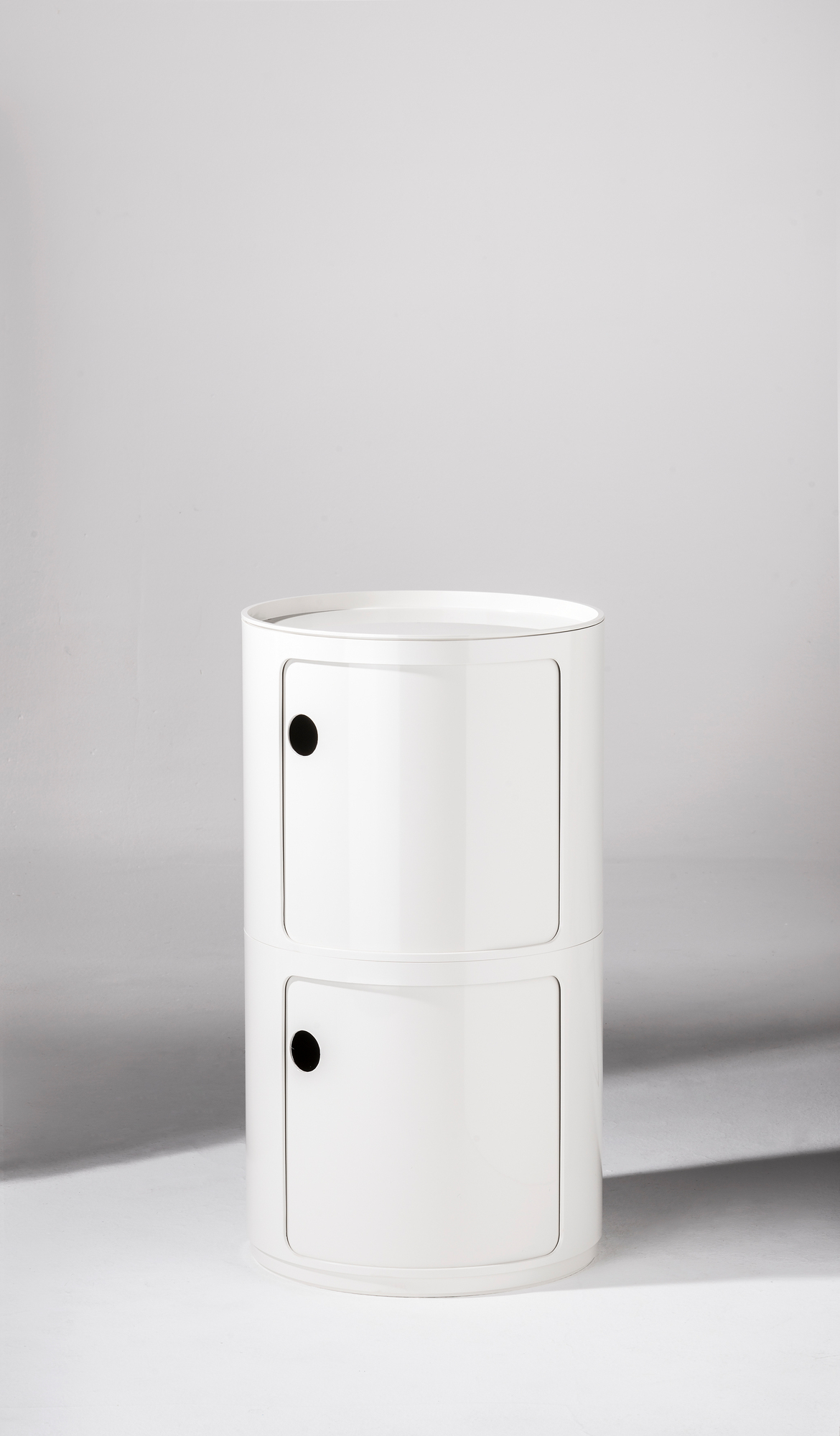 Componibili Aufbewahrungselement: Runder, weißer Nachttisch mit zwei Fächern und schwarzen Griffen. Modernes Design für Schlafzimmer.