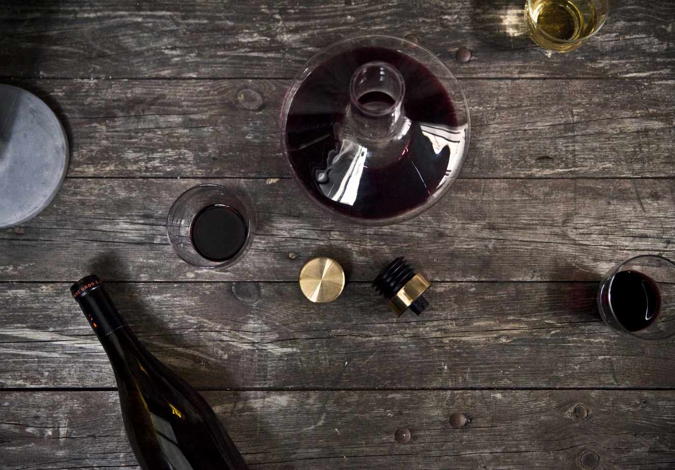 Aufsicht auf Audo Wine Breather Karaffe mit Rotwein, Gläsern und Flasche auf rustikalem Holztisch.