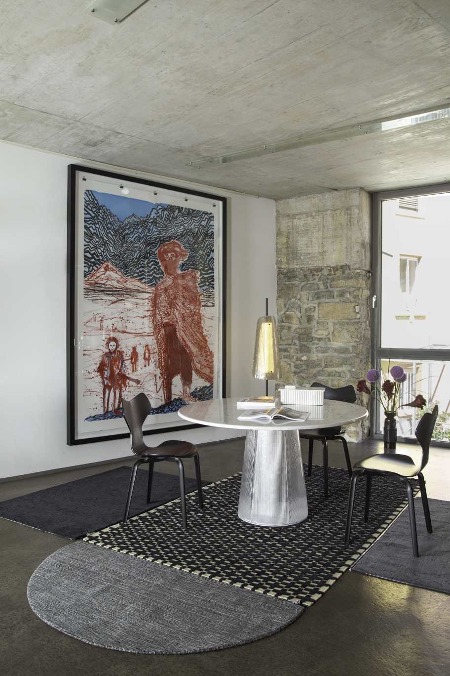 Weißer Bent Dining Table Esstisch mit geriffeltem Fuß und schwarzen Stühlen in modernem Interieur.