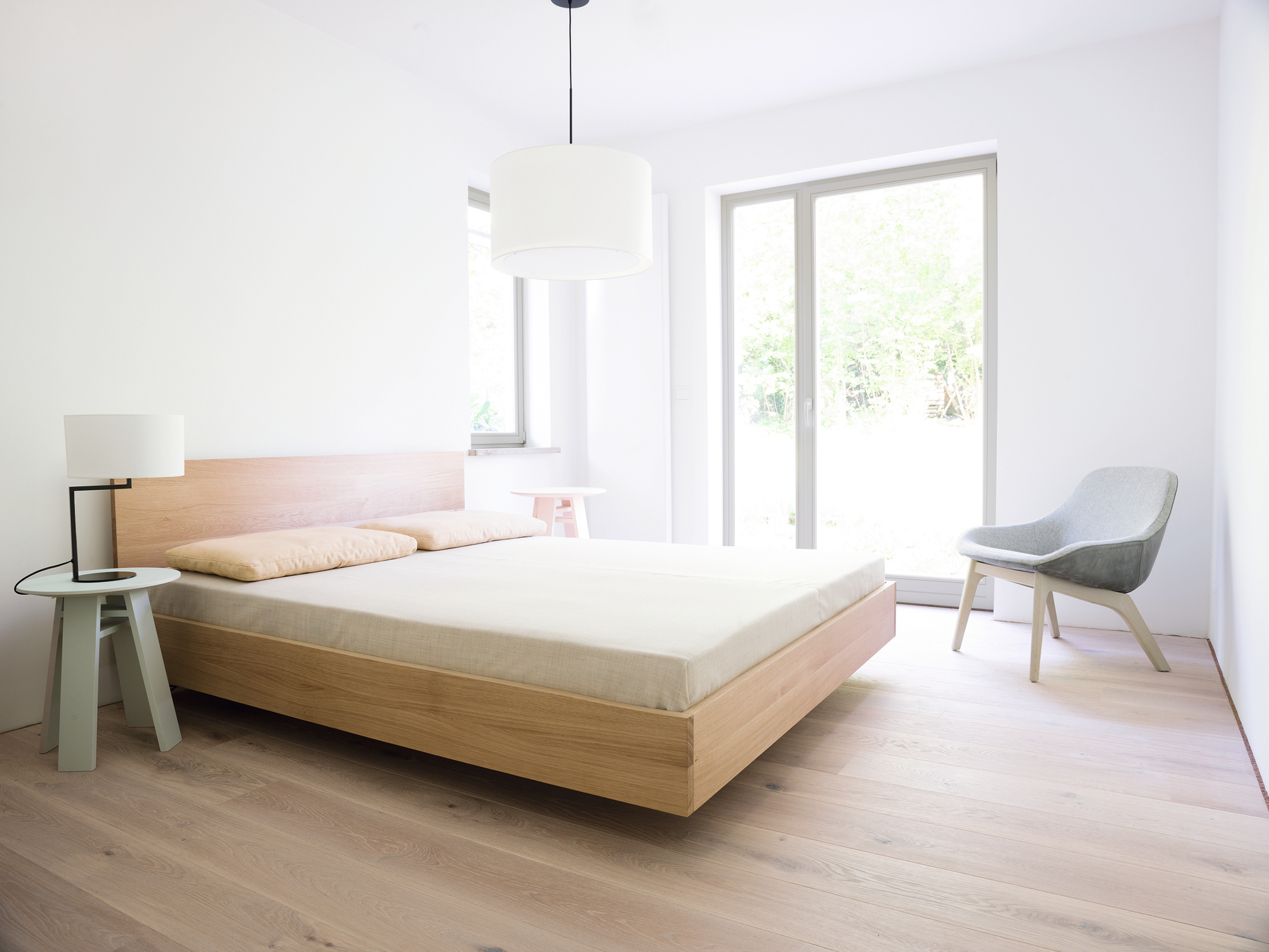 Schlafzimmer mit modernem Holzbett im Nussbaum-Design, passenden Nachttischen und hellem Interieur.