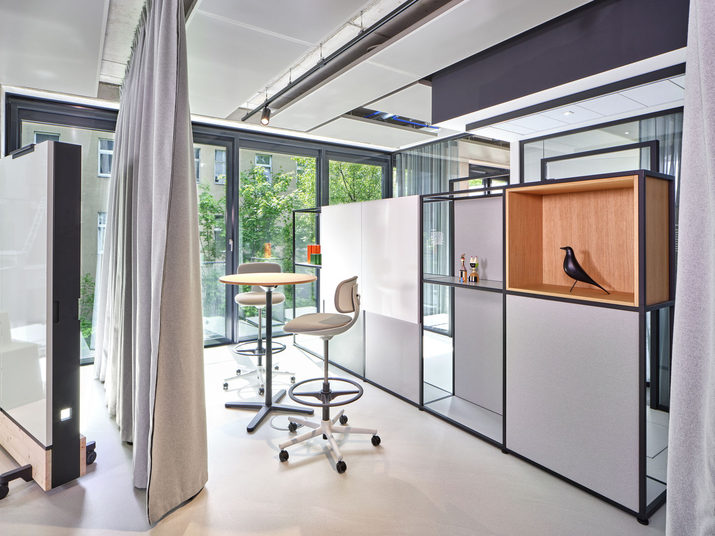 Innenaufnahme mit Vitra Rookie High Bürodrehstuhl, höhenverstellbar, in hellem Büro mit Fenster und Tisch.