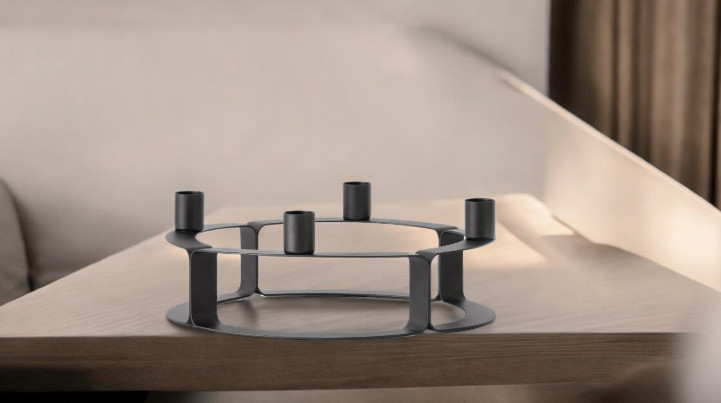 Schwarzer Lucca Kerzenständer von novoform für vier Kerzen auf einem Holztisch.