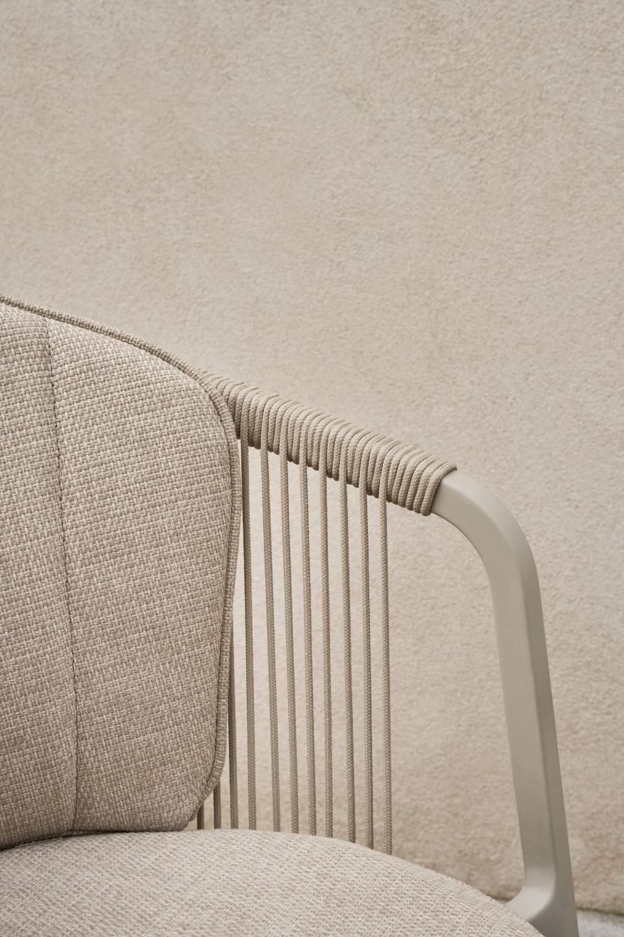 Detailaufnahme: Lagrasse Stuhl mit beigen Sitz- und Rückenkissen, Outdoor-Möbel mit Seil-Design.